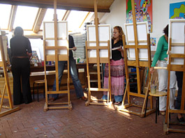 Workshop naaktmodel in de uiterwaarden van de Rijn schilderen naar naaktmodel, een aantal deelnemers zijn druk bezig goed naar het model te kijken en dit om te zetten naar een doek met acryl verf