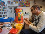 Keramische vaas met glazuur beschilderen op het atelier