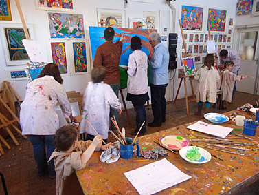 familieworkshop schilderen direkt op doek, opa, oma, kinderen en kleinkinderen maken samen een schilderij
