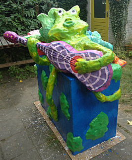 Polyester sculpture Ode to the earth by Twan de Vos, 3 frogs make music, accordion, guitar and wind instrument, singing about the beauty of their surroundings sing