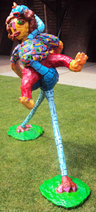 Polyester beeld Struisvogelboy van Twan de Vos, jongen rijdt op een struisvogel, om te blijven zitten heeft hij zijn trui over de hals van de struisvogel gedaan