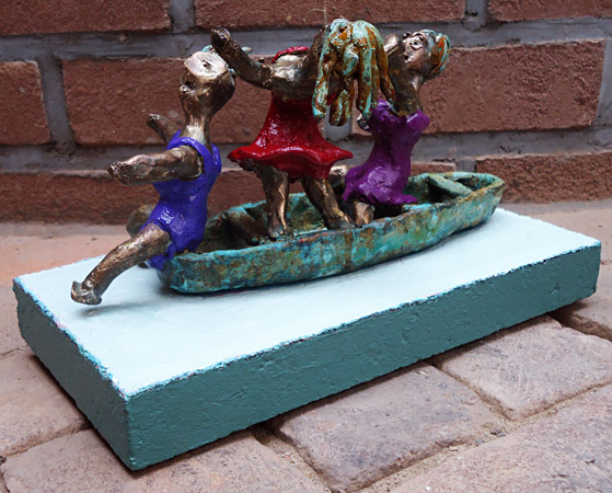 Painted bronze statue Pleasure Boating by Twan de Vos, three women dancing, singing and having fun on a boat