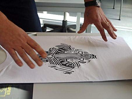 Workshop linosnede op t-shirt met textielverf, de tekening wordt op het linoleum gezet, wordt in spiegelbeeld afgedrukt op t-shirt met textielverf, als je tekst gebruikt moet de tekst in spiegelbeeld op het linoleum